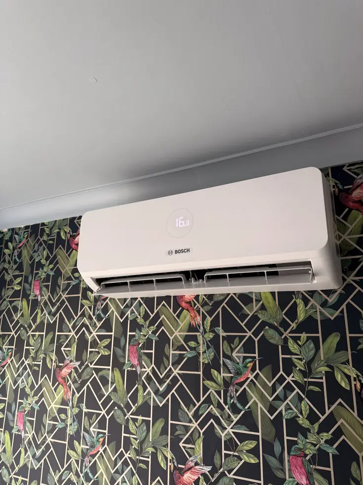 Bosch wall-mounted indoor air conditioning unit fitted above a bed